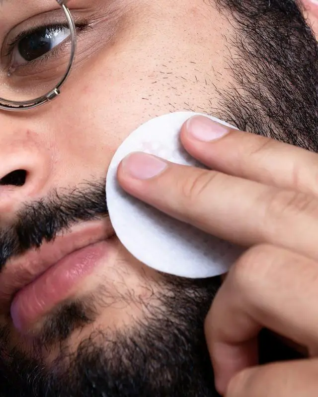 Man applying product onto beard