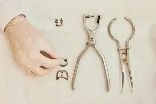 a person holding a pair of scissors next to a pliers