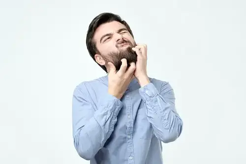 man scratching his beard