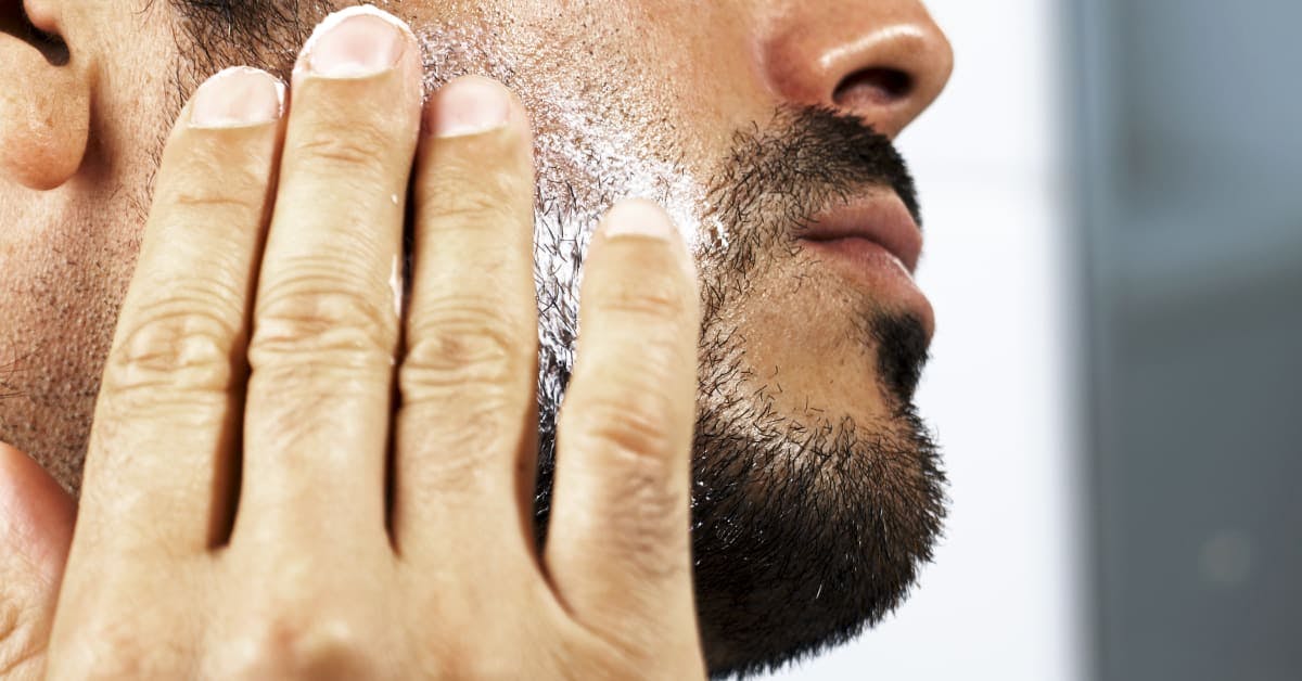 Man Spreading a moisturizer on his face