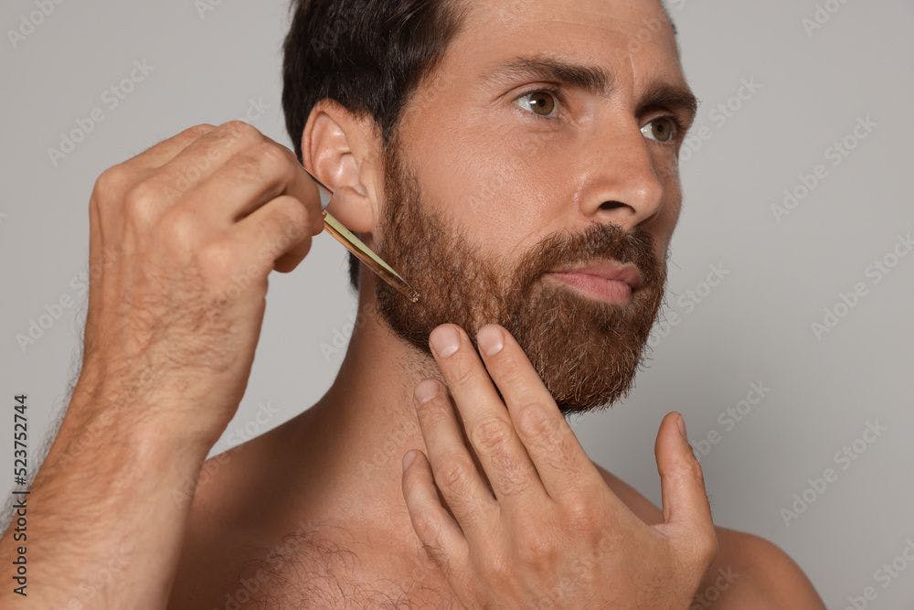 Man applying oil onto beard